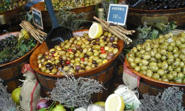 Ambiance de marché à Ansouis : des olives variées, des citrons, de l'ail et des herbes de Provence invitent à la dégustation.