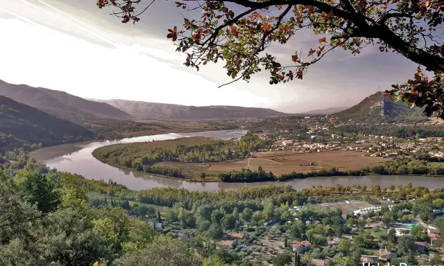 Vue panoramique d'une vallée avec une rivière sinueuse, des vignobles et un village. Idéal pour une randonnée à Pertuis.