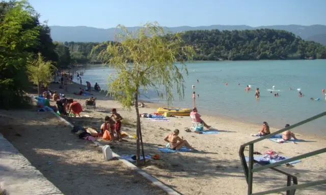 Plage animée à l'étang de la Bonde, baigneurs dans l'eau, familles sur le sable. Avis positif pour ce lieu de détente.