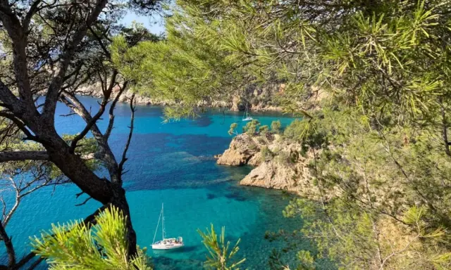 Vue sur la côte rocheuse et la mer turquoise de Bandol, avec des voiliers. Idéal pour savoir que faire à Bandol.