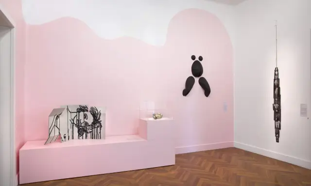 Exposition à la fondation Villa Datris : œuvres d'art contemporain sur fond rose, dont une sculpture abstraite noire et une installation de photos.