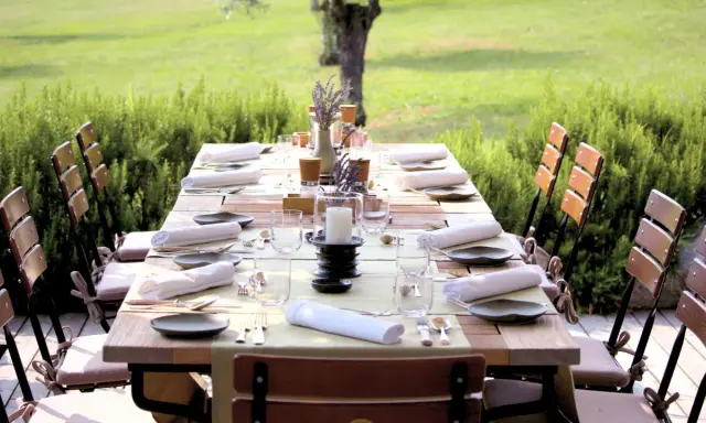 Table dressée pour un repas en plein air, entourée de verdure. Les vignes et son jardin offrent un cadre idyllique pour cette belle table.