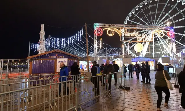 Un marché de Noël illuminé à Vaucluse, avec une grande roue et des chalets festifs.