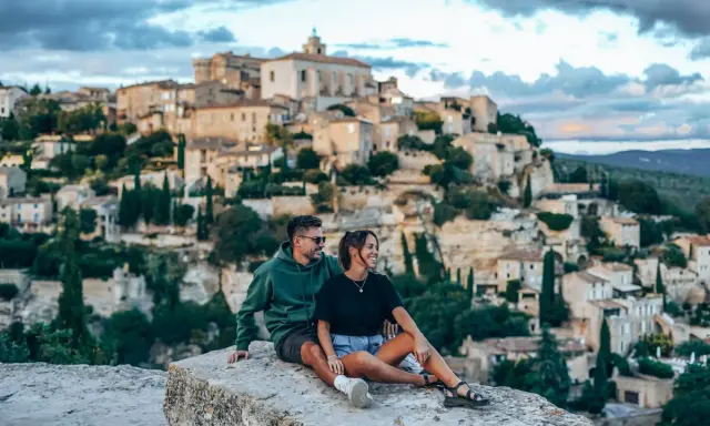 Couple en pause lors d'une randonnée à Gordes, profitant de la vue sur le village perché.