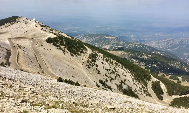 Vue panoramique depuis le sommet du Mont Ventoux, avec ses routes sinueuses et les **villes sur Auze** lointaines.