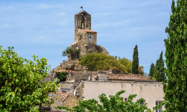 La tour de l'église de Lourmarin, perchée sur une colline rocheuse, domine le village. Un cadran solaire orne son flanc.