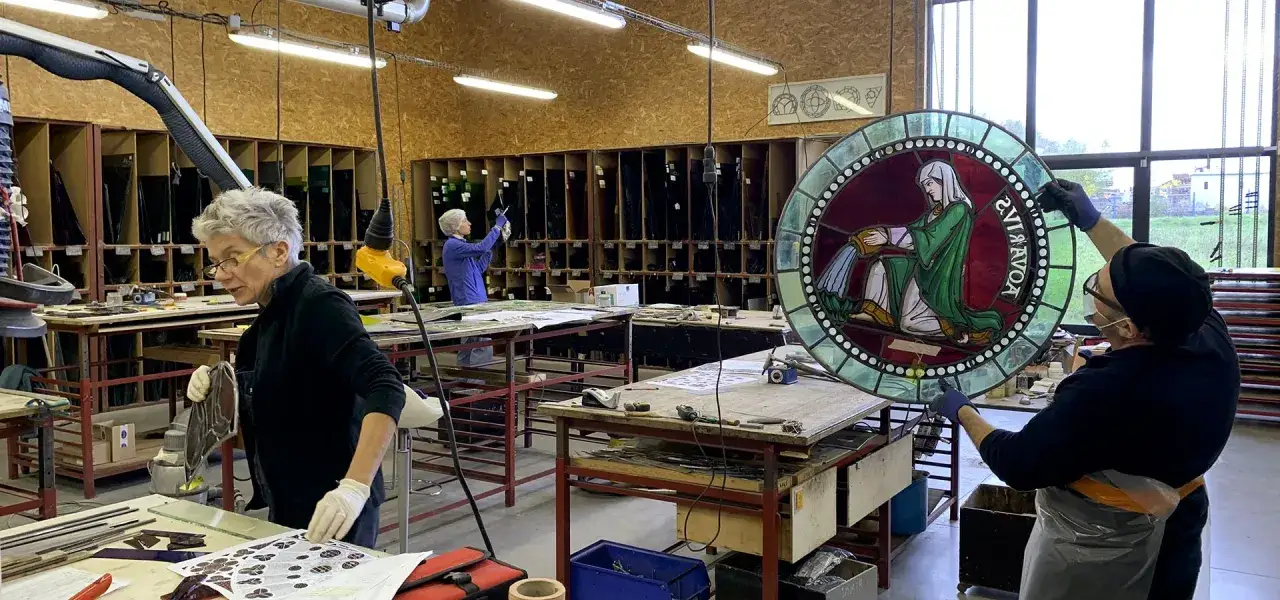 Atelier de restauration d'art, un musée du verre et du vitrail en pleine effervescence. Des artisans travaillent sur des pièces délicates.