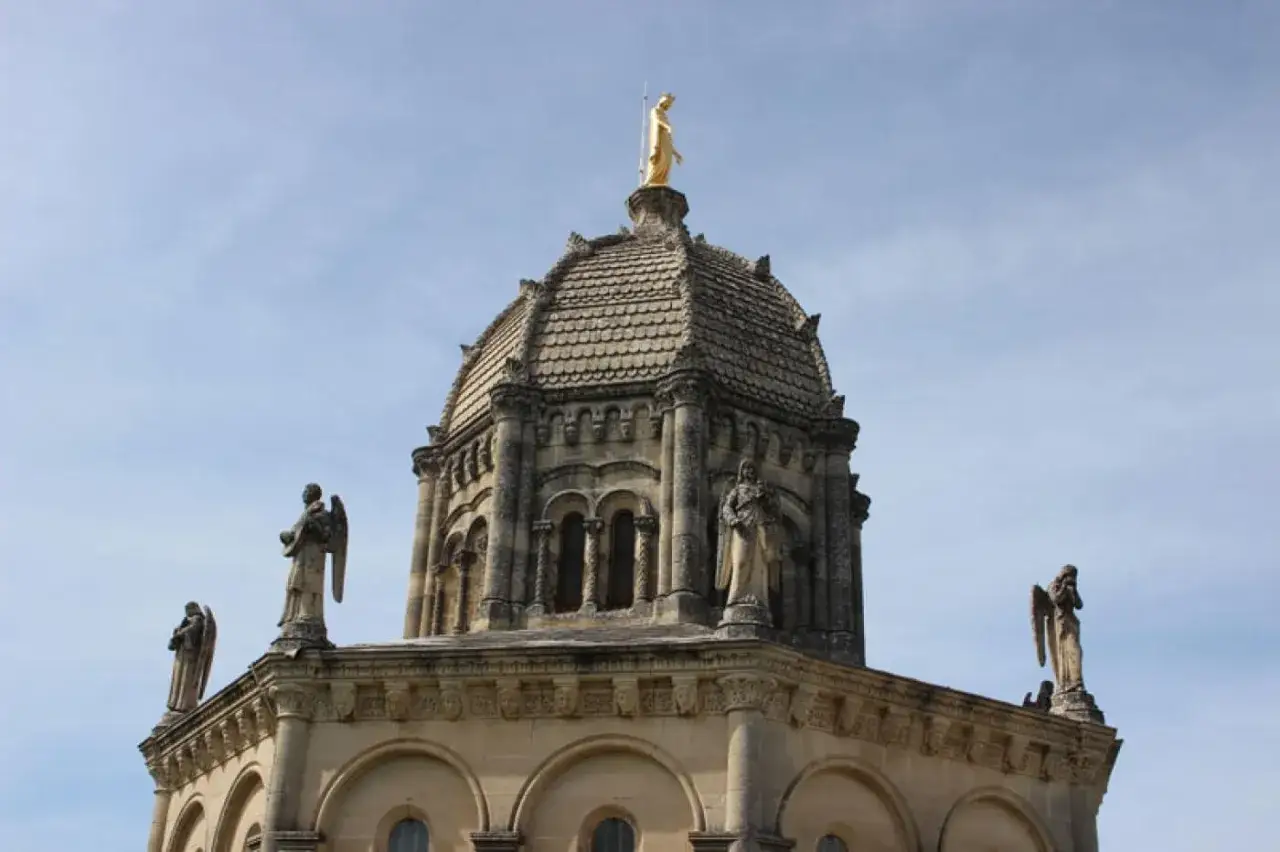 D&ocirc;me de Notre Dame de Provence, orn&eacute; de statues d'anges et surmont&eacute; d'une Vierge dor&eacute;e, sous un ciel bleu.
