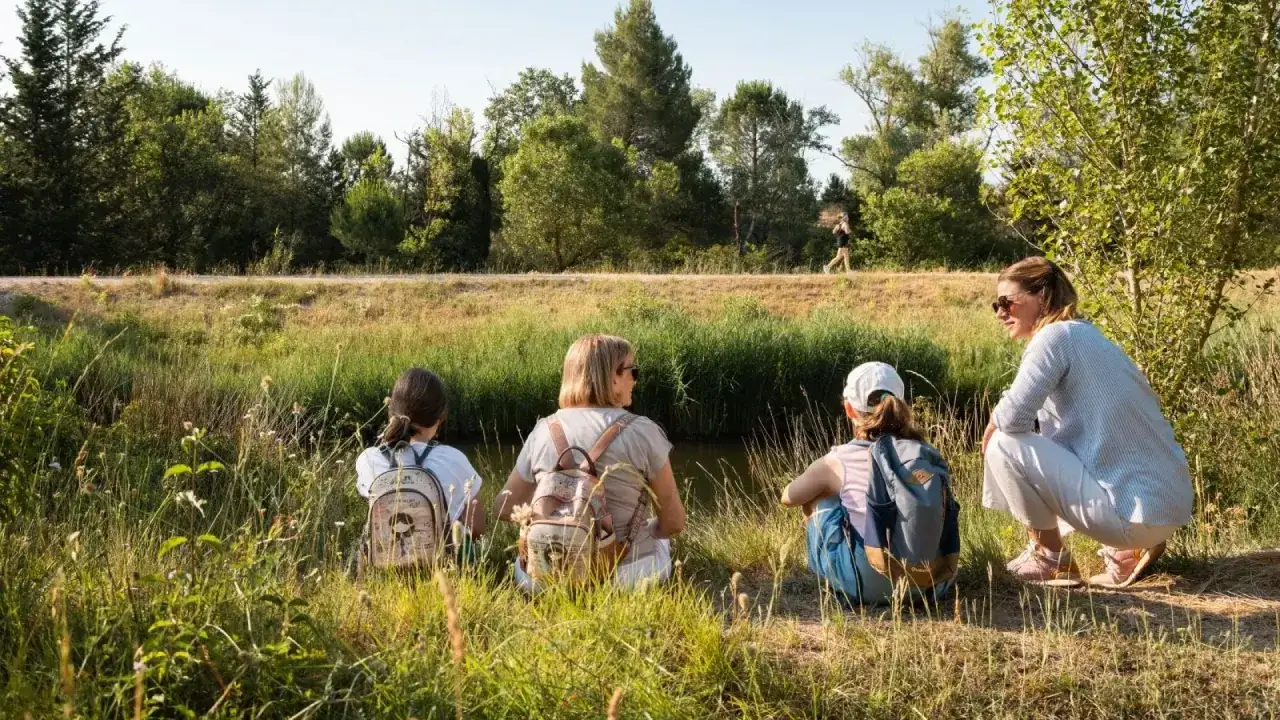 Famille profitant d'une belle journ&eacute;e ensoleill&eacute;e pour une activit&eacute; enfant Vaucluse, assise au bord de l'eau.