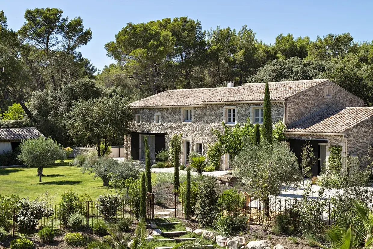Un mas en pierre typique du sud de la France, entour&eacute; d'un jardin luxuriant et d'arbres m&eacute;diterran&eacute;ens.