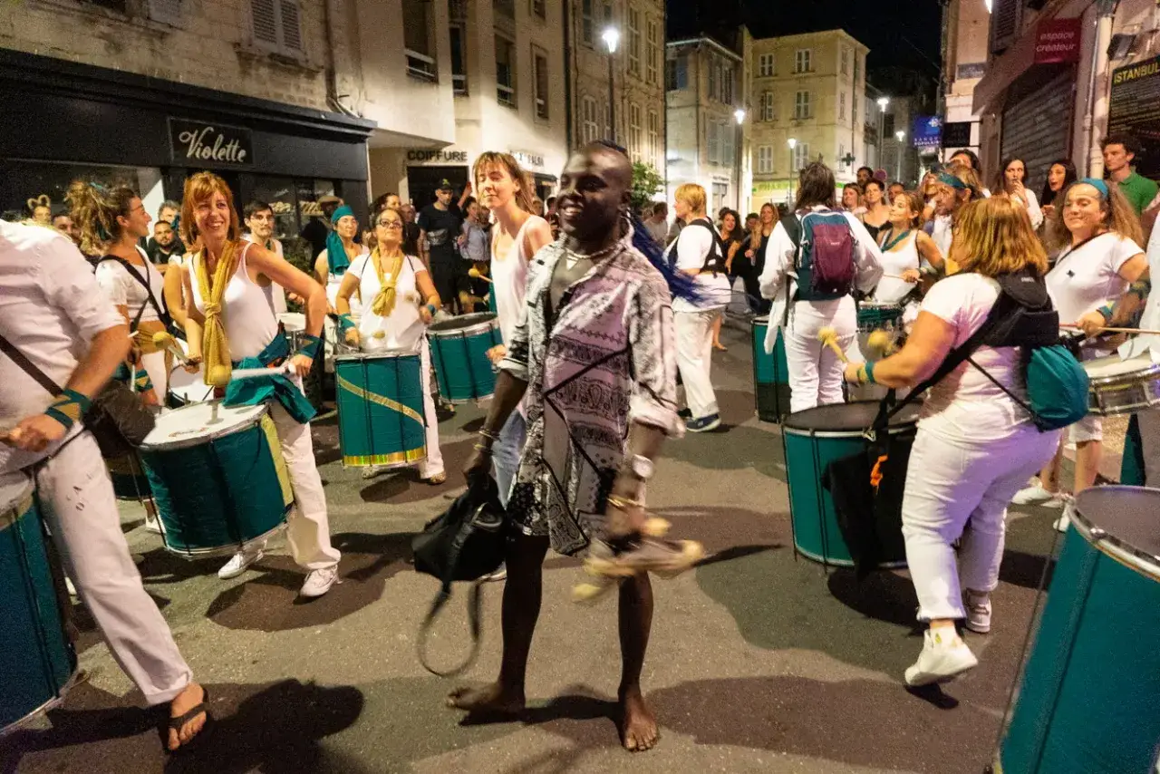 Une troupe de percussionnistes d&eacute;ambule dans les rues d'Avignon pour la F&ecirc;te de la Musique, leurs tambours r&eacute;sonnant dans la nuit.