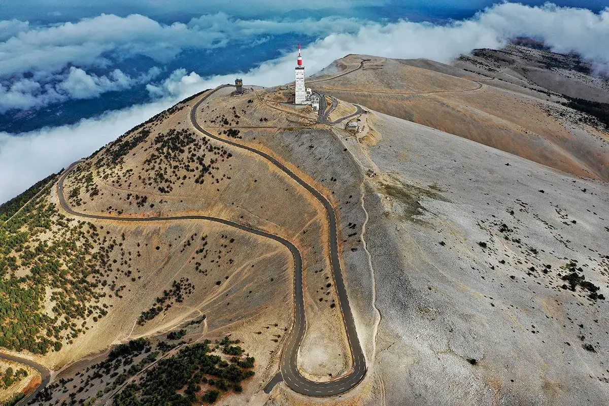 Vue a&eacute;rienne du tour du Mont Ventoux, avec ses lacets sinueux serpentant sur le flanc aride, domin&eacute; par une tour de t&eacute;l&eacute;communication.