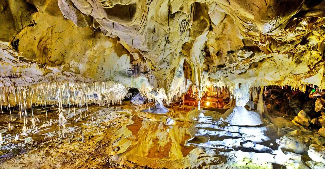 Grotte de Thouzon : une visite inoubliable. Stalactites, stalagmites et reflets dans l'eau créent un spectacle naturel.