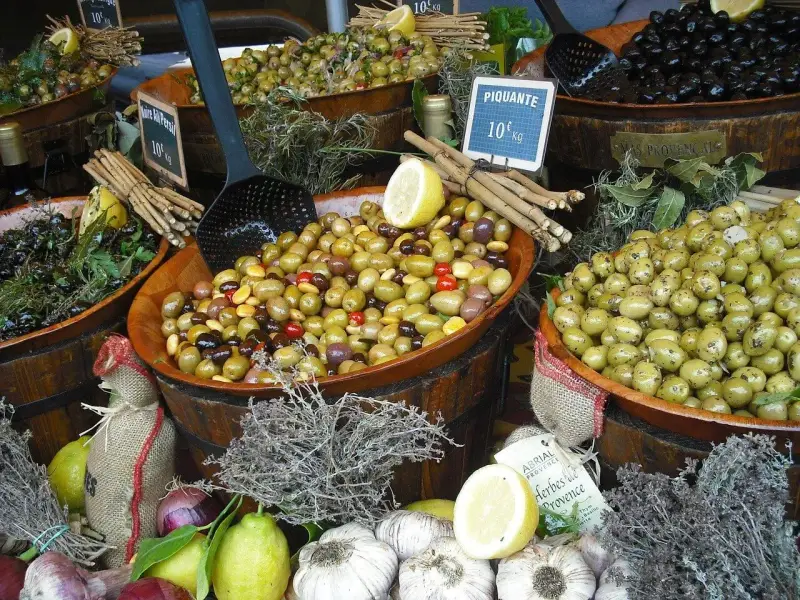 Ambiance de marché à Ansouis : des olives variées, des citrons, de l'ail et des herbes de Provence invitent à la dégustation.